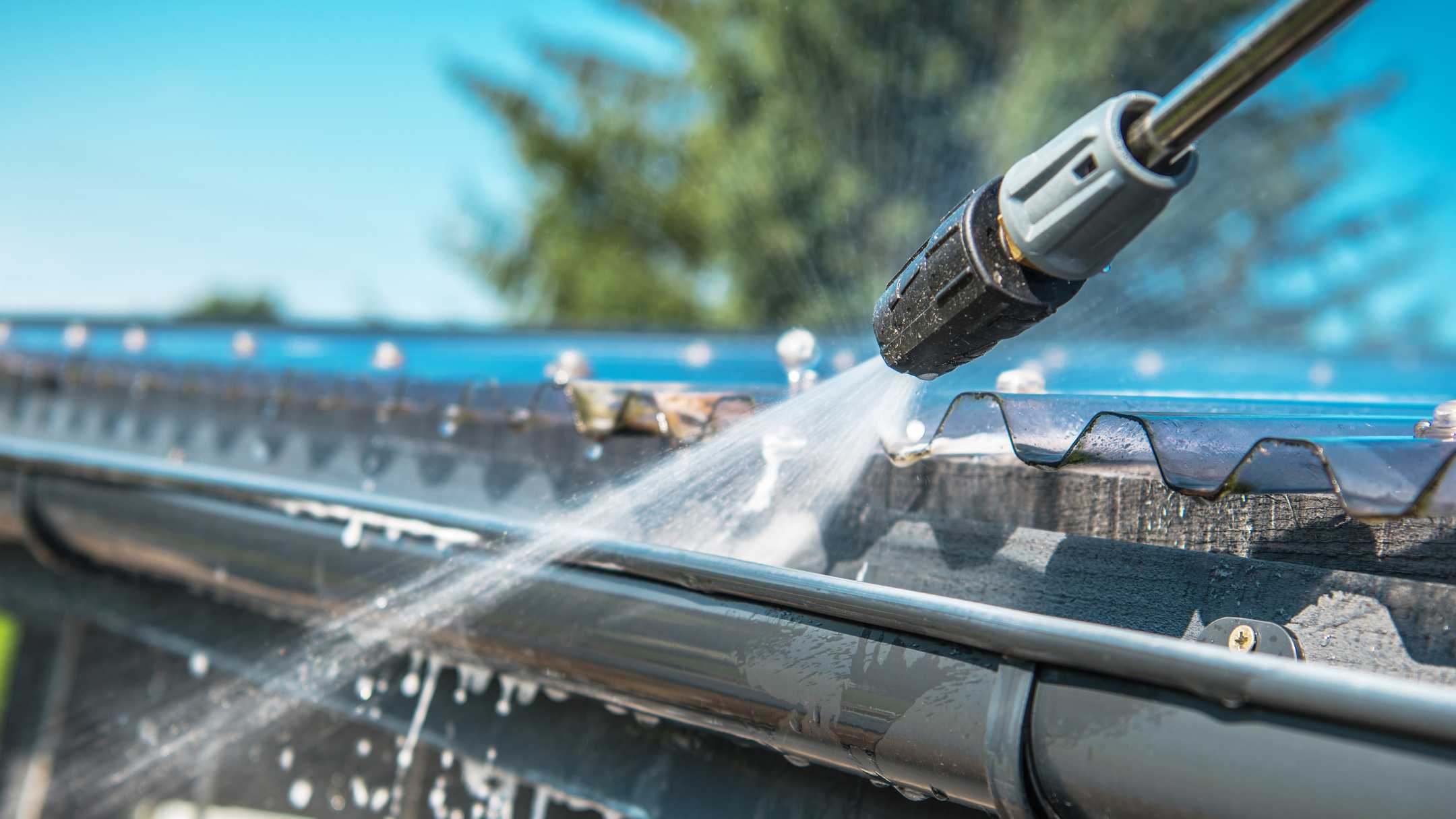 professional pressure washing roof and gutter of home